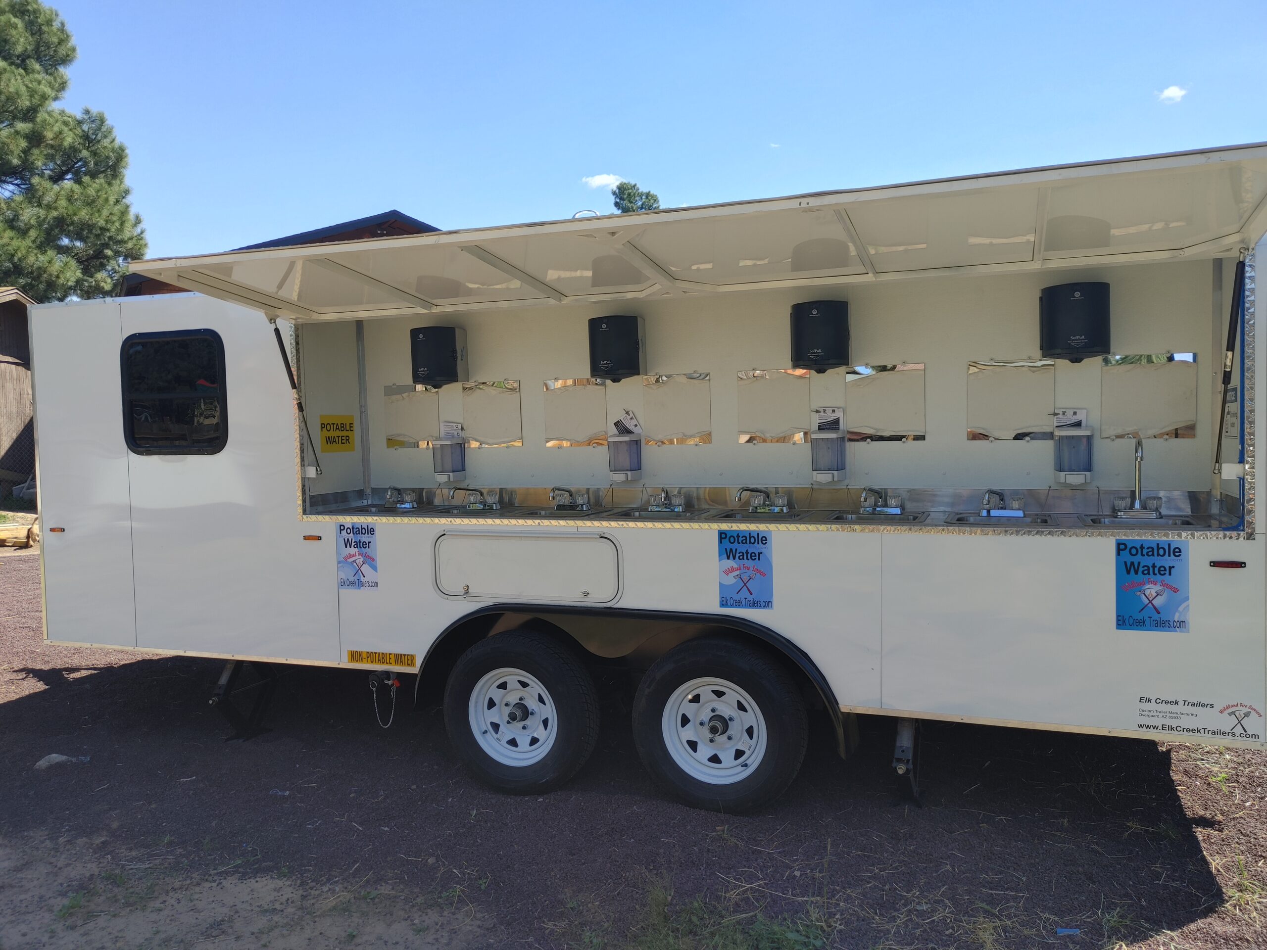 Side view of an 8 sink trailer with stainless steel sinks.