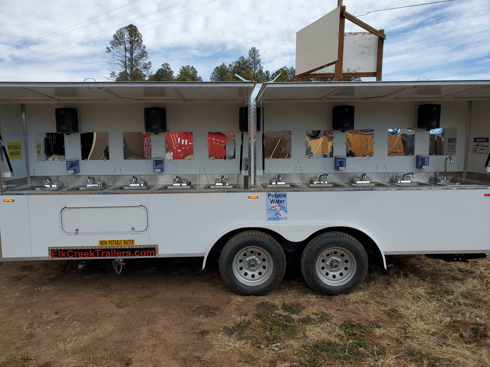 Side view of a 20 sink trailer with stainless steel sinks.